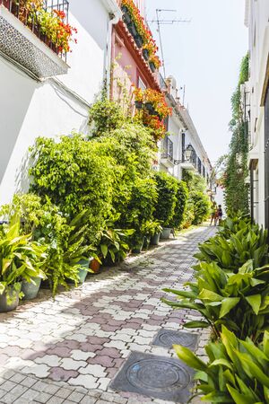 Vacation, narrow streets and typical of Marbella, white walls with floral balconies in Andalusia Spainの写真素材