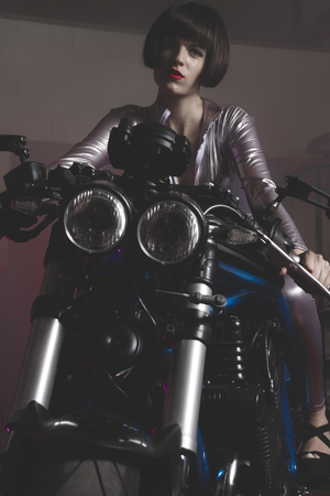 road, brunette with latex suit mounted on a bike with a modern designの写真素材