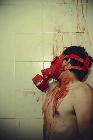 poison naked man with gas mask red blood in a bathroomの写真素材