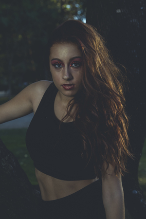 long-haired teenager in a forest or field with green meadowsの写真素材