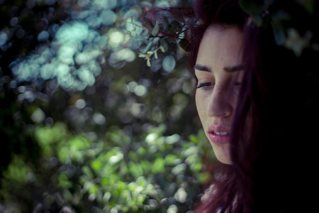 melancholic girl in a forest in autumn, red long hairの写真素材