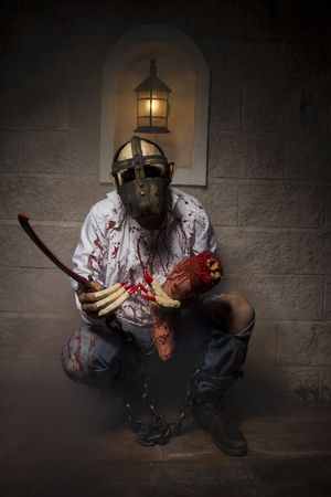 Man chained with blood and knife, has a severed leg bloodの写真素材