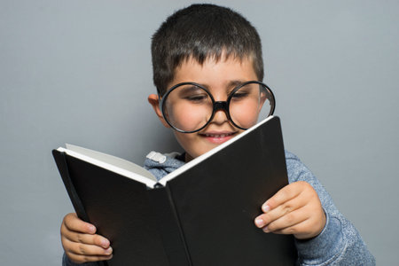 education, dark-haired young student reading a funny book, reading and learningのeditorial素材