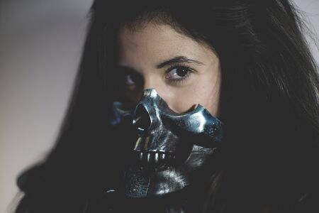 Skull mask, brunette sensual and sexy with weapons in aggressive and dangerous positionの写真素材