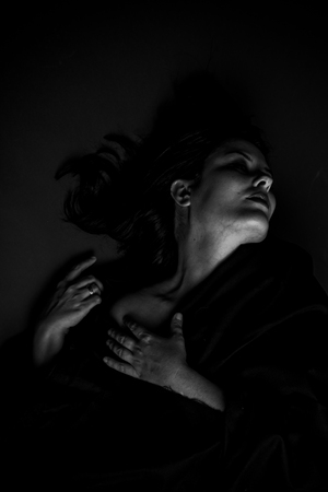 Vampire, gothic dark woman with large black cloth on gray background, Sadnessの写真素材