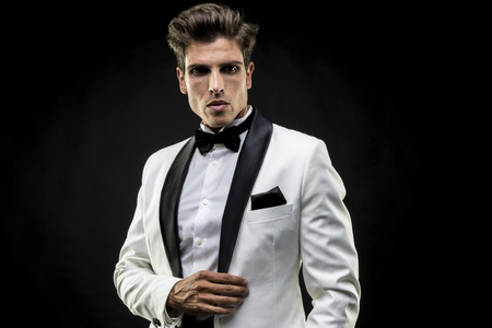 Boss, elegant man in a white suit tuxedo with bow tie around his neckの写真素材