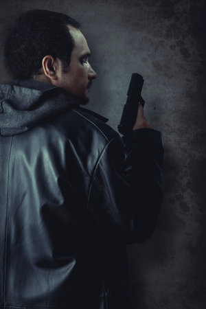 Man armed with gun on black textured background