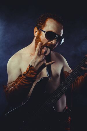 Performer, Rock star with electric guitar and concert hall smoke environmentの写真素材