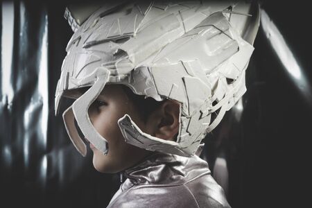 Funny Boy playing to be an astronaut with space helmet and metal suitの写真素材