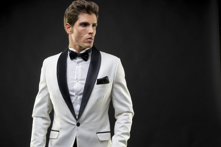 Luxury, elegant man in a white suit tuxedo with bow tie around his neckの写真素材