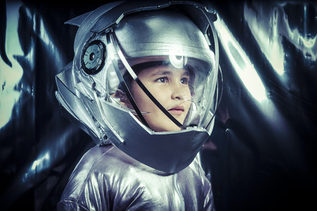 Boy playing to be an astronaut with space helmet and metal suitの写真素材