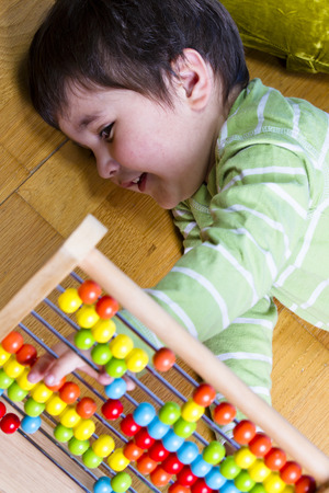 Funny little boy playing with abacus, studio shotの写真素材