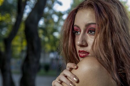 fall long-haired teenager in a forest or field with green meadowsの写真素材