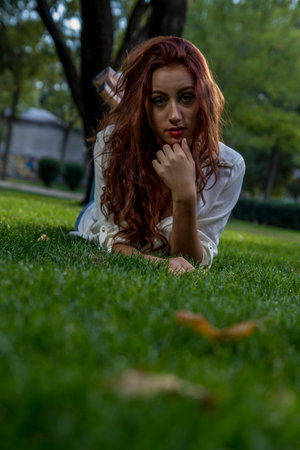 young long-haired teenager in a forest or field with green meadowsの写真素材