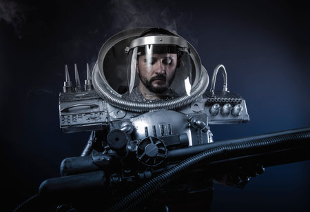 Cyborg, Space man, astronaut dressed in silver or metalized space suit. Armed with a laser gun and surrounded by smokeの写真素材