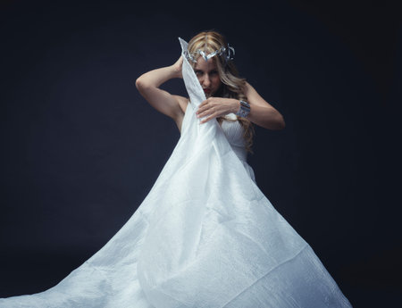 Beautiful greek blonde woman, mythology, dressed in white silk dress and laurel wreath handmade with...