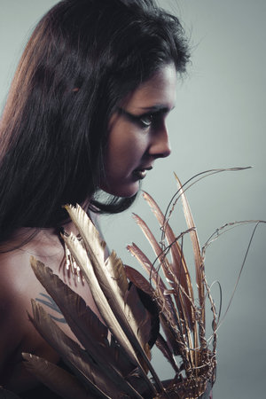 Sensuality and seduction, beautiful brunette girl with very long hair dressed in lace clothes and gold accessoriesの写真素材