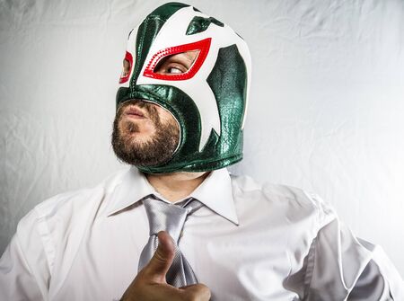 Angry businessman with iron mask on his face, is dressed in suit and tieの写真素材