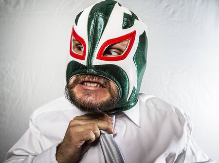 Executive, Angry businessman with iron mask on his face, is dressed in suit and tieの写真素材