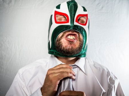 Stress, Angry businessman with iron mask on his face, is dressed in suit and tieの写真素材