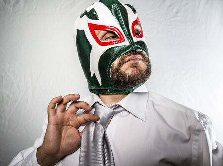 Angry businessman with iron mask on his face, is dressed in suit and tieの写真素材