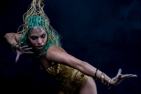 Golden Latin woman with green hair and gold costume with handmade flourishes, fantasy image and taleの写真素材