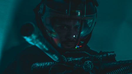 man of the future or space with futuristic helmet and fantasy lights, carries a laser weapon in his handsの写真素材