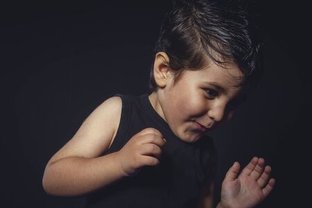 boy with hair gum in rocker dress with funny and expressive facesの写真素材