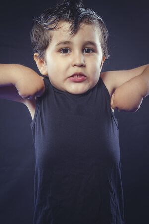 boy with hair gum in rocker dress with funny and expressive facesの写真素材