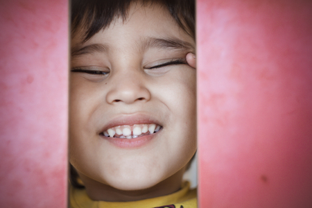 kid joking, Brunette boy putting funny faces in an outdoor parkの写真素材
