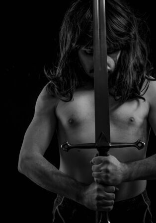 Faith, Wild warrior with metal sword and war paintings on the face, long hairの写真素材