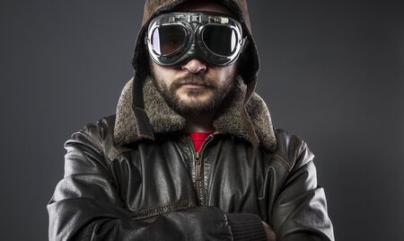 old airplane pilot with brown leather jacket, arador hat and large glassesの写真素材