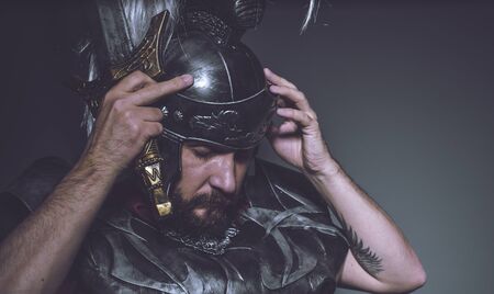 Roman gladiator, wrestler and warrior of Rome with helmet and red cloak, carries an iron sword, beard and long hair.の写真素材