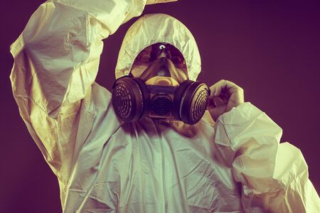 Contagious virus infection concept. Man in protective suit and antigas mask with glasses. Ebola, toxic gases, biological warfare, infections and diseasesの写真素材