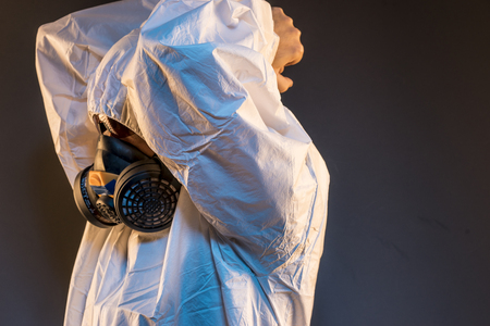 Safety virus infection concept. Man in protective suit and antigas mask with glasses. Ebola, toxic gases, biological warfare, infections and diseasesの写真素材