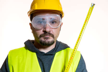 a man who wants to do a work without knowledge, work without experience. Do it yourself, man dressed in yellow builder helmet with protective glasses ready to start the construction workの写真素材