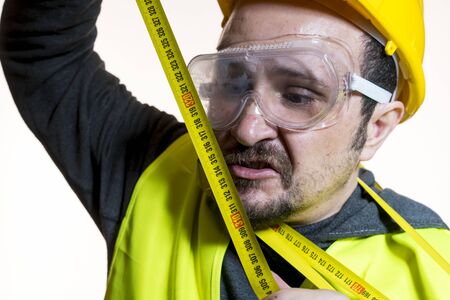 a man who wants to do a work without knowledge, work without experience. Do it yourself, man dressed in yellow builder helmet with protective glasses ready to start the construction workの写真素材