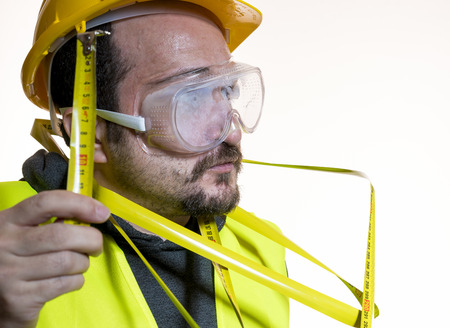 Man dressed in yellow builder helmet with protective glasses ready to start the construction workの写真素材