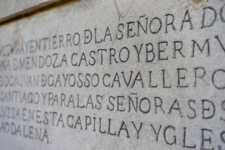 ancient writing in latin and ancient spanish carved on the stone inside a gothic cathedral in spain