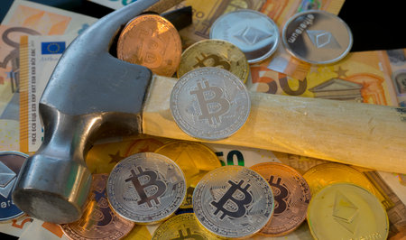 Bitcoin mining or mine for bitcoin, compared to the traditional idea of physical mining with a pickaxeの写真素材