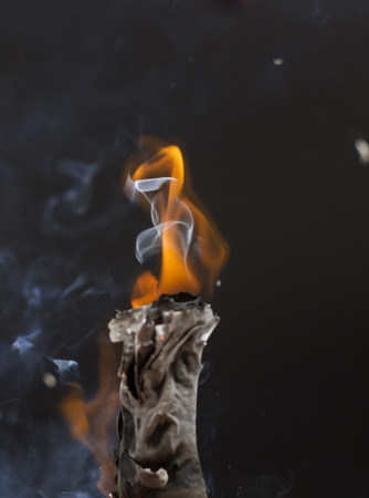 Burning cigarette with smoke on black backgroundの写真素材