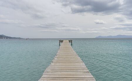 Wooden pier, calm turquoise waters in the Mediterranean Sea, holiday scenes with a sense of calmの写真素材