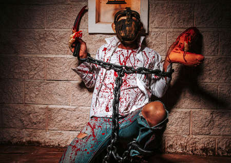 halloween costume, Man chained with blood and knife, Zombie man death the ghost horror drain hand blood skin is screaming darkness and nightmare background of scary fear on hell is monster devil  in halloween festival conceptの写真素材
