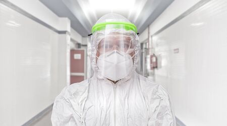 hospital corridor with male nurse wearing protective face mask, glasses and sanitary mask. coronavirus concept and hospital treatmentの写真素材