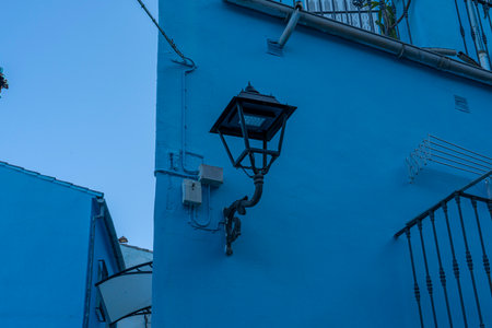 A picturesque view of JÃºzcar, the blue-painted village in Andalusia, Spain, bathed in morning sunlight. Perfect for travel brochures, cultural features, or serene landscape themes.の写真素材