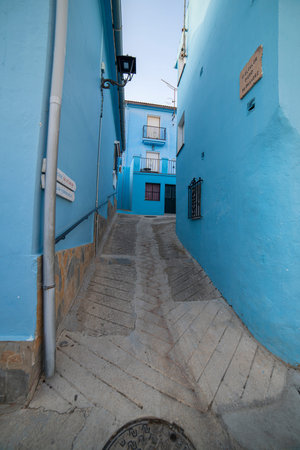A quiet alley in JÃºzcar, Spain, lined with vibrant blue buildings, capturing the unique charm of the "Smurf Village." Perfect for travel, architecture, or cultural themes.の写真素材