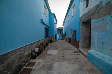 A quiet alley in JÃºzcar, Spain, lined with vibrant blue buildings, capturing the unique charm of the "Smurf Village." Perfect for travel, architecture, or cultural themes.の写真素材