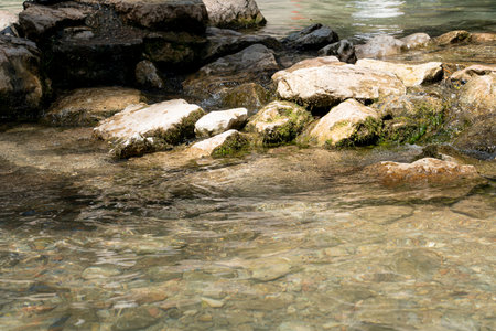 Limestone rocks line the clear waters of Cueva del Gato, reflecting sunlight as the serene...