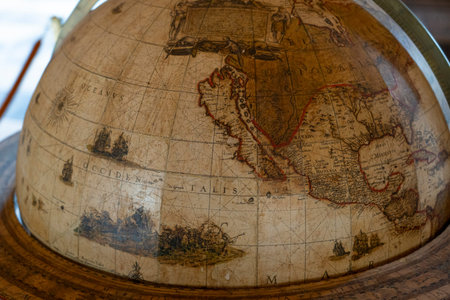 An antique globe illustrates historical cartography with detailed depictions of North America,...
