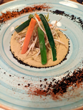 Colorful vegetables arranged on a creamy base., plate